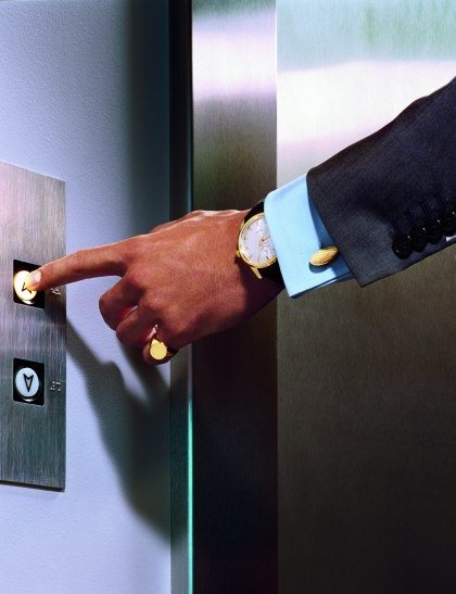 мужчина нажимает кнопку лифта